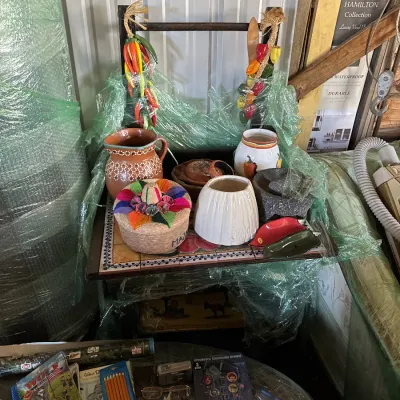 Sale Photo Thumbnail #105: Collection of Southwestern and Mexican kitchenware including a mosaic tiled rolling cart, terracotta pitcher, molcajete, and woven sombreros.