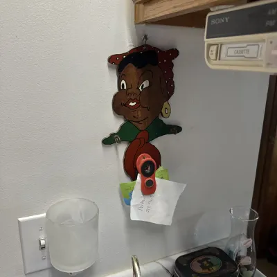 Sale Photo Thumbnail #27: Vintage Mammy-style wooden wall hanger with hooks mounted on a kitchen wall below a cabinet.