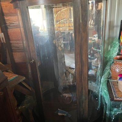 Sale Photo Thumbnail #186: Antique dark wood curved glass curio cabinet featuring a single front door and interior shelving.