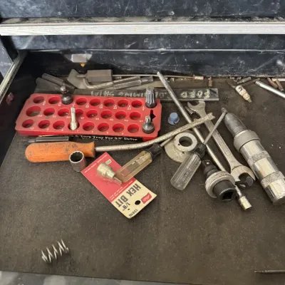 Sale Photo Thumbnail #81: Open tool chest drawer containing an assortment of loose hand tools, driver bits, screwdrivers, wrenches, and a red bit holder tray.