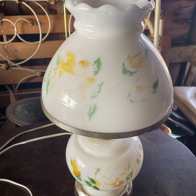 Sale Photo Thumbnail #185: Vintage white milk glass hurricane table lamp featuring hand-painted yellow flowers and green leaves with a ruffled top rim.