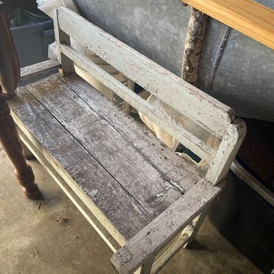Sale Photo Thumbnail #202: Rustic weathered wooden bench featuring distressed white paint and a slatted backrest.