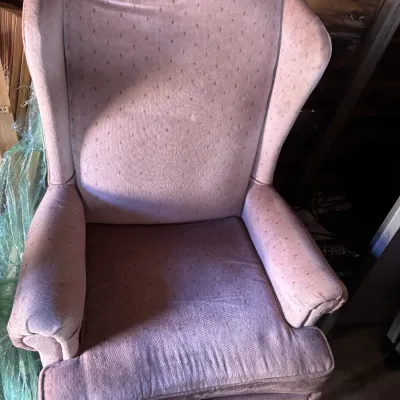 Sale Photo Thumbnail #112: Vintage mauve upholstered wingback armchair featuring a subtle patterned fabric and rolled arms.