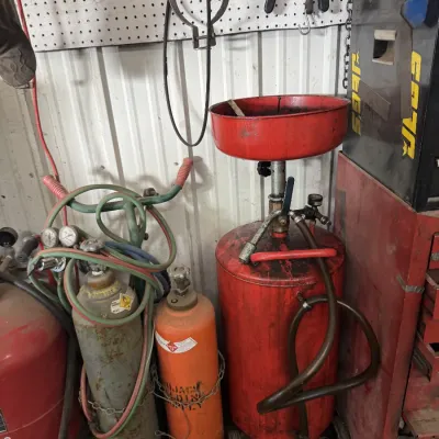 Sale Photo Thumbnail #72: Pneumatic waste oil drain tank alongside an oxy-acetylene torch cart setup with gas cylinders.