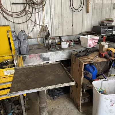 Sale Photo Thumbnail #66: Workshop tools and equipment including a bench grinder, metal pedestal tray, power tools, and various hardware accessories.