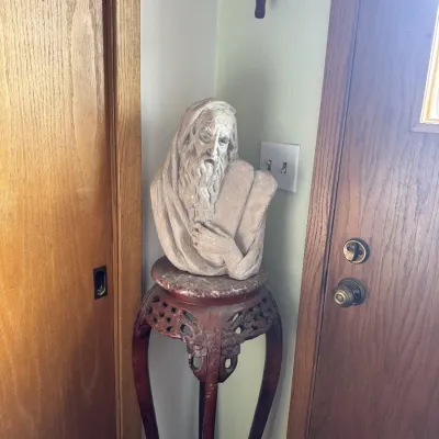 Sale Photo Thumbnail #52: Plaster bust of Moses holding the Ten Commandments, displayed on a carved wooden plant stand with a marble top.