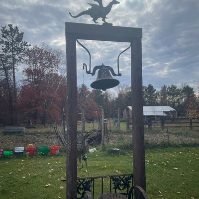 Sale Photo Thumbnail #167: Large cast iron farm bell mounted on a wooden frame topped with a dragon weather vane silhouette.