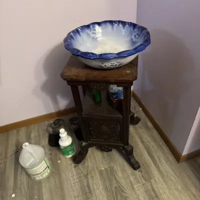 Sale Photo Thumbnail #11: Vintage dark wood two-tier plant stand featuring carved details, topped with a blue and white flow blue style ceramic wash basin.