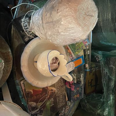 Sale Photo Thumbnail #198: Collection of mixed household items, including a white ceramic pitcher and bowl set with blue trim, Janis Joplin vinyl record, and plastic-wrapped table lamp.