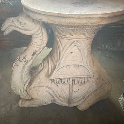 Sale Photo Thumbnail #197: Vintage cast concrete or terracotta camel-shaped garden side table, featuring a seated camel design with a flat top surface and a weathered off-white finish.