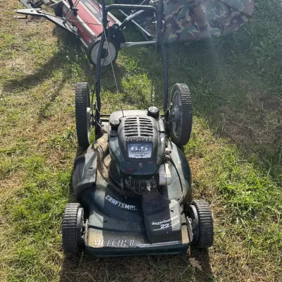 Sale Photo Thumbnail #101: Craftsman 6.5 horsepower 22-inch self-propelled lawn mower, displaying moderate wear from use.
