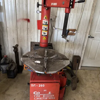 Sale Photo Thumbnail #97: Red TC-260 tire changer machine showing heavy surface wear and usage marks.