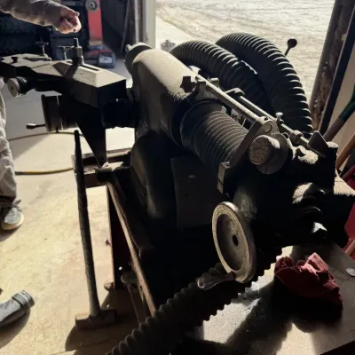 Sale Photo Thumbnail #93: Vintage heavy-duty industrial lathe or metalworking machine with attached flexible dust collection hoses, mounted on a steel workstand.