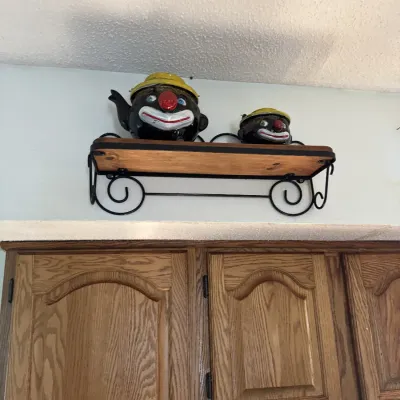 Sale Photo Thumbnail #35: Vintage ceramic novelty teapot and matching sugar bowl shaped like clown faces with yellow hats, displayed on a wall-mounted wooden shelf.