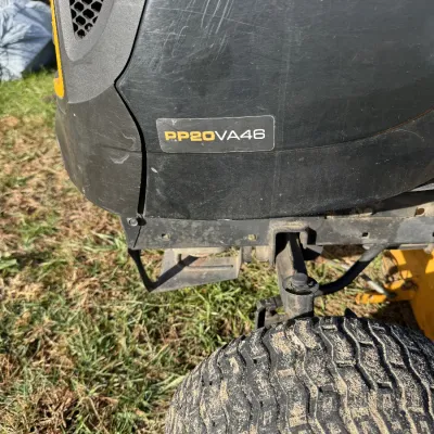 Sale Photo Thumbnail #125: Detail view of a Poulan Pro PP20VA46 riding lawn mower showing model emblem and front tire.