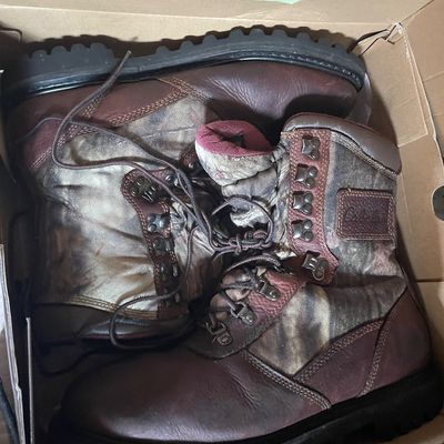 Sale Photo Thumbnail #193: Pair of Cabela's camouflage and brown leather outdoor hunting boots, stored in their original cardboard box.