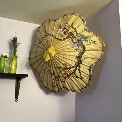 Sale Photo Thumbnail #10: Vintage wall-mounted paper and bamboo parasol featuring hand-painted floral cherry blossom motifs, showing some tears and wear to the paper canopy.