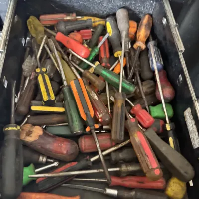 Sale Photo Thumbnail #87: Toolbox drawer filled with a large assortment of vintage and modern screwdrivers in various sizes and handle colors.