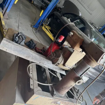 Sale Photo Thumbnail #92: Vintage Craftsman radial arm saw mounted on a cabinet base in an auto shop setting.