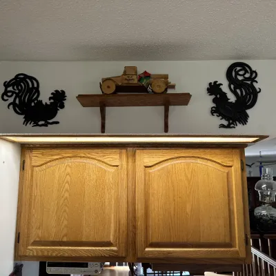 Sale Photo Thumbnail #29: Pair of vintage black metal rooster wall silhouettes flanking a small wooden shelf with a hand-carved toy truck.