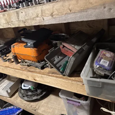 Sale Photo Thumbnail #57: Workshop shelving filled with assortment of tools, plastic toolboxes, socket sets, and automotive supplies.