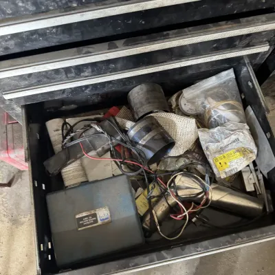 Sale Photo Thumbnail #88: Open black metal tool chest drawer filled with miscellaneous automotive tools, including an OTC electronic ignition analyzer case, timing light, and hardware.