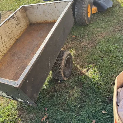 Sale Photo Thumbnail #117: Heavy-duty tow-behind utility cart attached to a Poulan Pro riding lawn mower, showing surface rust and wear from use.