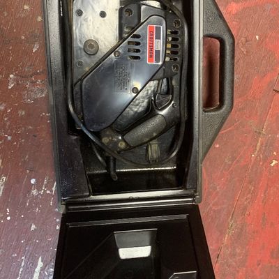 Vintage Sears Craftsman electric belt sander stored inside its original black hard plastic carrying case.