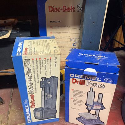 Vintage Dremel power tool attachment boxes including a Deluxe Moto-Lathe Kit Model 701, a Drill Press Model 210, and a Disc-Belt Sander...
