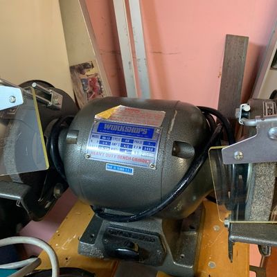 Vintage Workshops 6-inch heavy duty bench grinder with dual wheels and protective eye shields.