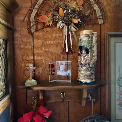 Rustic wall decor display featuring a wooden coat rack shelf holding a vintage ceramic German beer stein, acrylic Footprints prayer...