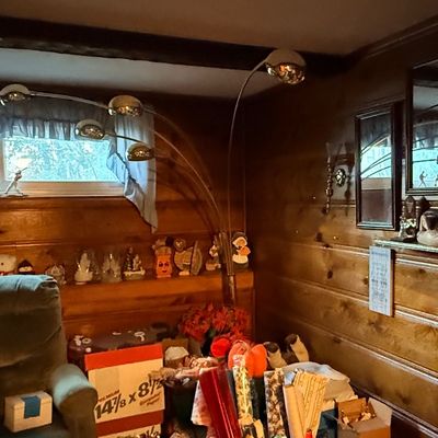 Vintage mid-century chrome multi-head arc floor lamp featured in a wood-paneled room with assorted plush toys and home decor.