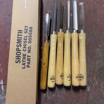 Shopsmith lathe chisel set (part no. 505586) featuring six woodturning tools with light and dark wooden handles, alongside their original...