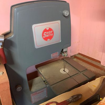 Shopsmith bandsaw attachment in grey plastic casing, showing normal dust and wear from use.