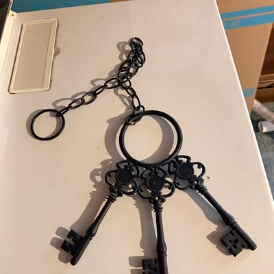 Decorative wrought iron key ring featuring three oversized skeleton-style keys attached to a chain.