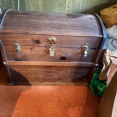 Vintage dome-top wooden steamer trunk with brass hardware and latches.