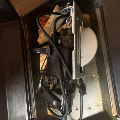 Vintage Sears Craftsman worm drive circular saw, stored inside its original black molded plastic carrying case alongside original paperwork.