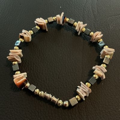 Sale Photo Thumbnail #199: Handcrafted-style beaded bracelet featuring natural sliced puka/heishe shell chips interspersed with metallic gold-tone round beads and dark metallic cube beads. Secured with a barrel twist clasp. Good pre-owned condition with no visible damage.