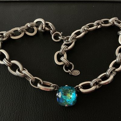 Sale Photo Thumbnail #156: A designer chain necklace by Catherine Popesco France featuring a central faceted cushion-cut blue-green crystal stone set in a heavy silver-tone oval-link chain. Includes designer metal hangtag stamped 'Catherine Popesco France'. Shows minimal surface we