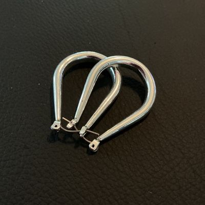 Sale Photo Thumbnail #222: Pair of silver-tone teardrop-shaped hoop earrings featuring snap-bar closures. Each earring measures approximately 1.25 inches in length. In good pre-owned condition with light surface wear.