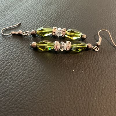 Sale Photo Thumbnail #212: Pair of dangle drop earrings featuring olive green elongated faceted glass beads accented with clear faceted crystal spacers and rhinestone rondelles on wire French hooks. Good condition with light metal patina.