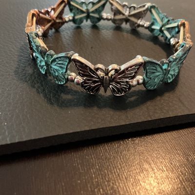 Sale Photo Thumbnail #211: Costume stretch bracelet featuring alternating butterfly links in verdigris green patina, copper-tone, and silver-tone finishes with small silver-tone spacer beads. Elastic band design allowing for flexible sizing. Shows light wear consistent with pre-own