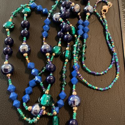 Sale Photo Thumbnail #209: Multi-strand long statement necklace featuring a vibrant mix of royal blue, teal green, purple, and gold-tone beads, including faceted, iridescent, and seed beads. Includes a lobster claw clasp and a small hangtag stamped with the Chico's logo. Shows mino