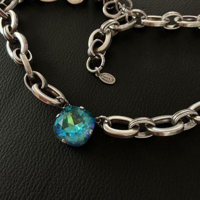 Sale Photo Thumbnail #157: A designer chain necklace by Catherine Popesco France featuring a central faceted cushion-cut blue-green crystal stone set in a heavy silver-tone oval-link chain. Includes designer metal hangtag stamped 'Catherine Popesco France'. Shows minimal surface we