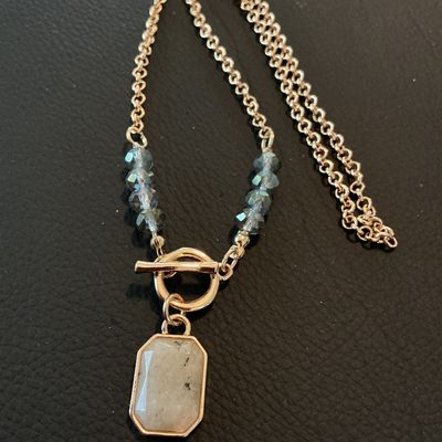Sale Photo Thumbnail #189: Fashion costume necklace featuring a gold-tone rolo chain, front toggle closure, iridescent smoke-grey faceted beads, and an octagonal bevel-set light stone pendant. Good condition with light signs of wear.