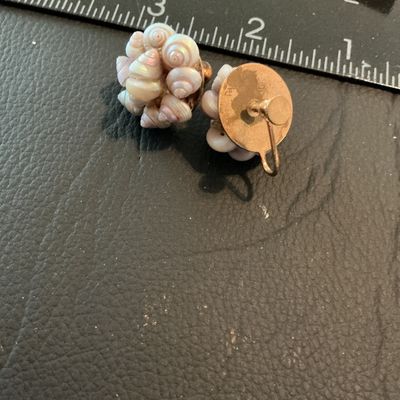 Sale Photo Thumbnail #181: Pair of vintage screw-back cluster earrings composed of small, iridescent, pearlescent spiral sea shells mounted on a gold-tone metal backing. Each earring measures approximately 3/4 inch in diameter. Good vintage condition with intact shells and function
