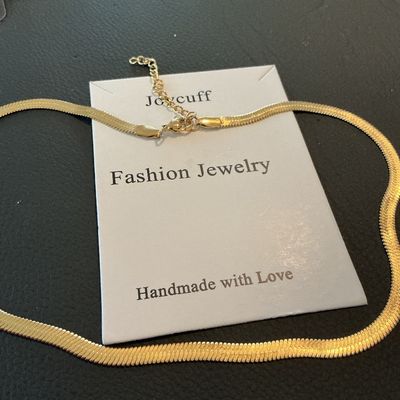 Sale Photo Thumbnail #188: Joycuff fashion jewelry gold-tone herringbone flat snake chain necklace with an adjustable extender chain and lobster claw clasp. Presented on original card backing. Appears to be in unused condition with no visible wear.