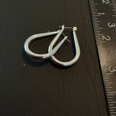 Sale Photo Thumbnail #223: Pair of silver-tone teardrop-shaped hoop earrings featuring snap-bar closures. Each earring measures approximately 1.25 inches in length. In good pre-owned condition with light surface wear.