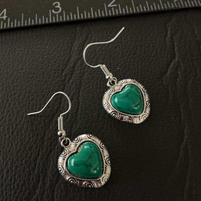 Sale Photo Thumbnail #129: Pair of silver-tone dangle earrings featuring heart-shaped charms with ornate scrollwork borders and marbled green stone or resin cabochon centers. Equipped with French wire fishhook ear wires. The heart charms measure approximately 0.75 inches long. Pre-