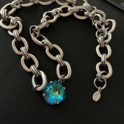 Sale Photo Thumbnail #158: A designer chain necklace by Catherine Popesco France featuring a central faceted cushion-cut blue-green crystal stone set in a heavy silver-tone oval-link chain. Includes designer metal hangtag stamped 'Catherine Popesco France'. Shows minimal surface we